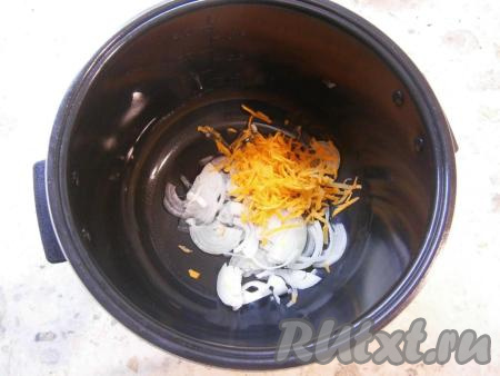 Растительное масло влить в чашу мультиварки, затем выложить лук, нарезанный полукольцами (или четвертинами), и натертую на крупной терке морковь.