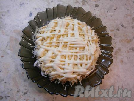 Далее идёт слой сыра, натертого на мелкой терке, нанести сеточку из майонеза.