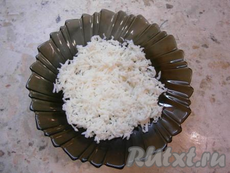 Лук, вареные яйца и отварную морковь очистить. Сливочное масло поместить в морозилку. Очищенные яйца разделить на белки и желтки. Затем белки, натерев на крупной (или средней) терке, выложить в салатник первым слоем.