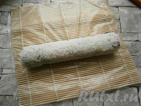 С помощью циновки плотно свернуть большой ролл.