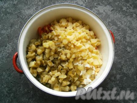 Сюда же добавить нарезанные такими же кубиками соленые огурцы и картофель.