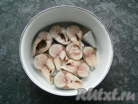 Нарезать рыбу на кусочки шириной около 1,5 см, сложить их в лоток или небольшую кастрюльку в один слой. Лук и чеснок очистить.