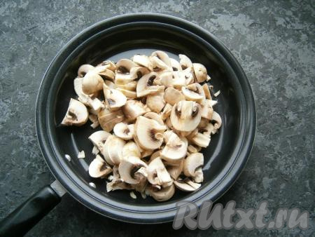 Разогреть растительное масло в сковороде, затем выложить шампиньоны, нарезанные на пластины.