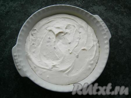 Высыпать в форму 2/3 подготовленной крошки, чуть ее утрамбовать. Сверху выложить всю творожную массу, разровнять.