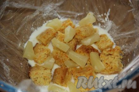 Затем выложить слой из кусочков бисквита и кусочков ананасов, полить сметанным кремом.