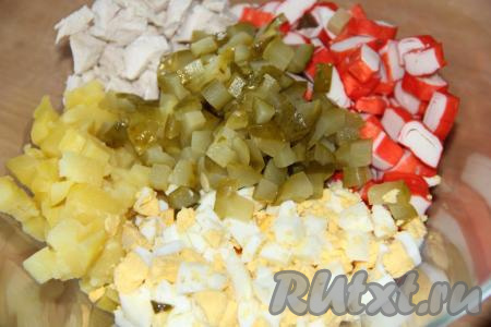 Маринованные огурчики нарезать на кубики и добавить в салат. Желательно, чтобы и огурцы, и картошка, и яйца, и крабовые палочки, и куриная грудка в этом салате были нарезаны на кубики, примерно, равной величины (не надо резать ни слишком крупно, ни слишком мелко).