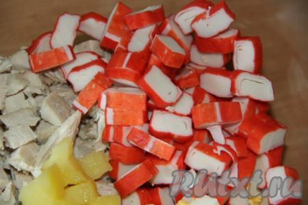 Крабовые палочки заранее разморозить при комнатной температуре, затем нарезать на средние кусочки и выложить в салат из картошки и куриной грудки.