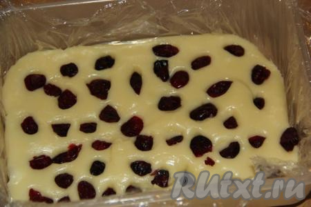 В тёплую массу выложить вяленую клюкву, немного вдавливая её в массу.