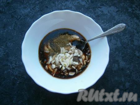 Влить соевый соус, всыпать соль, специи, черный перец и&nbsp;сухую аджику, добавить измельченный чеснок.