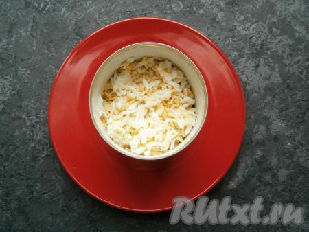 Два яйца натереть на средней терке, оставшееся яйцо разделить на белок и желток. Белок оставить, а желток натереть и добавить к яйцам. Тертые яйца выложить следующим слоем.