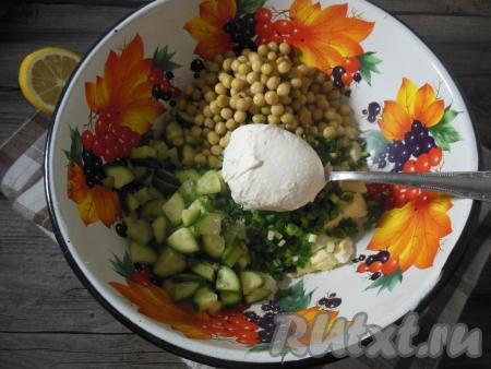 В глубокой миске смешайте нарезанные куриные яйца, зеленый лук, огурчики (немного огурцов оставьте для украшения), добавьте зеленый горошек без жидкости. Заправьте салат лимонным соком, щепоточкой соли, смесью молотых перцев и сметаной (или майонезом).&nbsp;