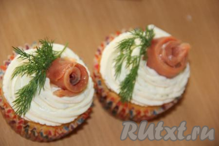 Тонкие ломтики сёмги свернуть в рулетик и вставить в середину сырной&nbsp;шапочки. Украсить закусочные кексы веточкой укропа и сухими пряностями.