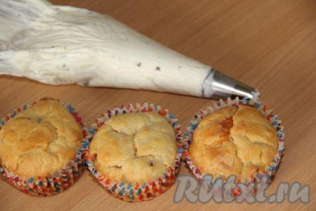 Сыр предварительно достать из холодильника (где-то за час до украшения выпечки). В кондитерский мешок с фигурной насадкой выложить творожный сыр.