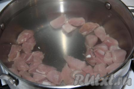 Свинину нарезать средними кубиками, выложить в кастрюлю и залить 2,8 литрами холодной воды.&nbsp;