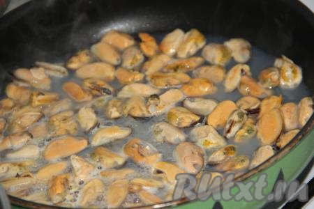 Выложить мидии в сковороду (я использовала замороженные мидии и предварительно их не размораживала), поставить на огонь. Тушить мидии на среднем огне, иногда перемешивая, в течение минут 15. Вначале будет много жидкости, но в процессе тушения мидий жидкость постепенно испарится.