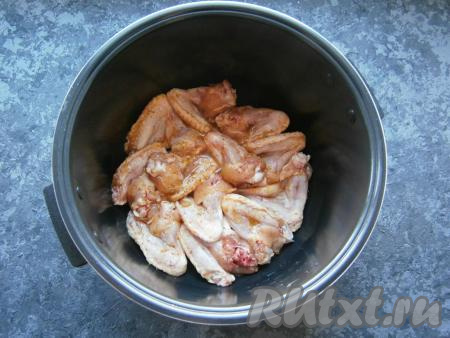 Хорошенько перемешать крылья с соусом. В чашу мультиварки выложить сливочное масло и влить растительное. Уложить крылышки в один слой плотненько друг к другу.