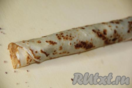 Завернуть блин с начинкой в плотный рулет.