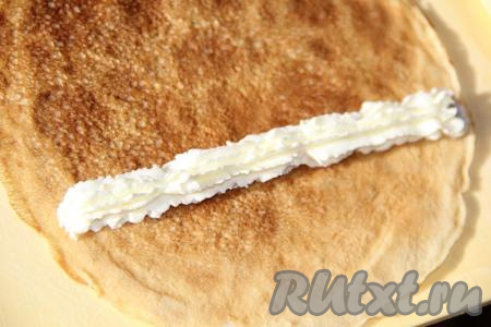 Переложить сыр в кулинарный мешок. Отсадить сыр на блинчик в виде полоски.