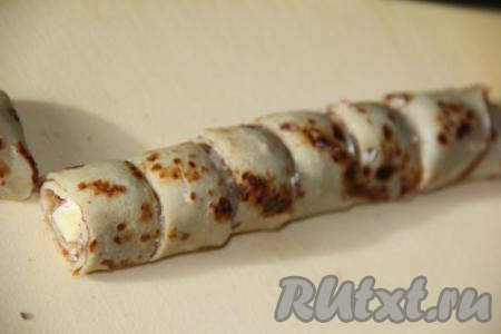 Острым ножом нарезать блинный рулет на кусочки (роллы). Используя блинчики и оставшуюся фруктовую начинку, сформировать все роллы. Из этого количества ингредиентов получается 20-25 наивкуснейших блинных роллов с фруктами (блинчики ещё останутся).