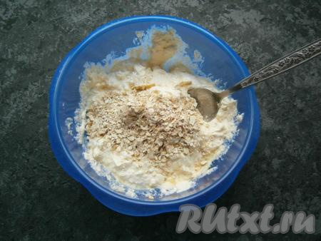 Всыпать овсяные хлопья, перемешать ложкой и оставить творожную массу на 15 минут.