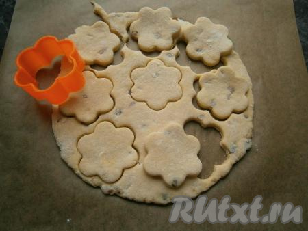 На столе, припыленном мукой, тесто раскатать в лепешку толщиной около 0,5 см. Стаканом или формочкой вырезать печенюшки.