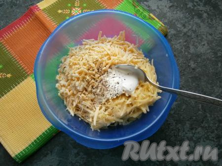 Добавить натертый на крупной терке сыр, сметану, соль, чёрный молотый перец и измельченный чеснок.