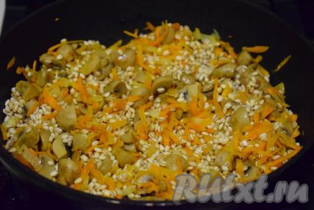 С перловой крупы сливаем воду, в которой перловка замачивалась. В сковороду к&nbsp;тушеным овощам и шампиньонам выкладываем разбухшую перловую крупу.