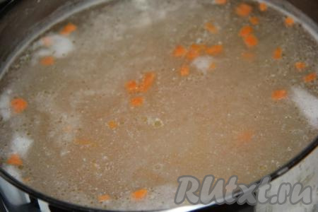 Нарезанные мясо, картофель и морковь выложить в кипящий куриный бульон, уменьшить огонь и варить суп 15-20 минут.