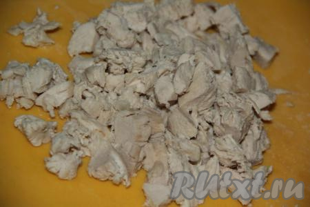 Куриную грудку залить 2,5 литрами воды и варить минут&nbsp;20 с момента закипания на небольшом огне, затем достать мясо из бульона и нарезать на кусочки.