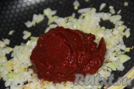 Когда лук станет золотистого цвета, выложить к нему томатную пасту, перемешать.