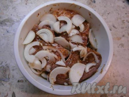 Складывать свиные стейки слоями (по 3-4 штуки в один ряд), пересыпая каждый слой полукольцами лука.