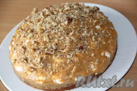 Смазать безе кремом, посыпать орехами и снова выложить слой безе, но уменьшая диаметр торта. Тортик должен получиться "горкой". Смазать безе кремом, посыпать орешками. Поставить бисквитный торт в холодильник на несколько часов.