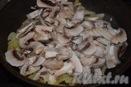 Добавить к луку шампиньоны, нарезанные на пластины (или крупные кусочки), накрыть содержимое сковороды крышкой.