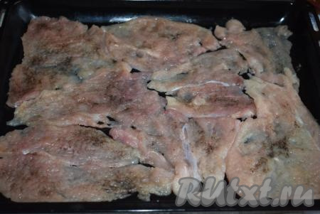 Выкладываем отбивные на противень, смазанный растительным (или сливочным) маслом. Мясо солим, перчим, посыпаем специями по вкусу. Даем отбивным постоять минут 10-15, чтобы мясо просолилось и пропиталось специями.