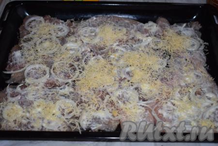 На смазанные майонезом отбивные выкладываем натертый сыр. Я использовала 2 вида сыра (но можно взять и какой-то один вид сыра твёрдых сортов). "Российский" сыр я натираю на мелкой терке и выкладываю его на мясо.