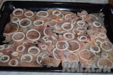 Лук очистим и нарежем кольцами. Выкладываем колечки лука на отбивные. Количество лука регулируйте по своему вкусу. Я обожаю лук в этом блюде и с удовольствием бы добавила 2 луковицы, но мои дети не любят лук, поэтому его количество уменьшаю.