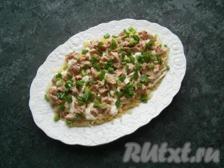 Измельчить печень трески и выложить её поверх картошки. Посыпать слой печени измельченным зеленым луком.