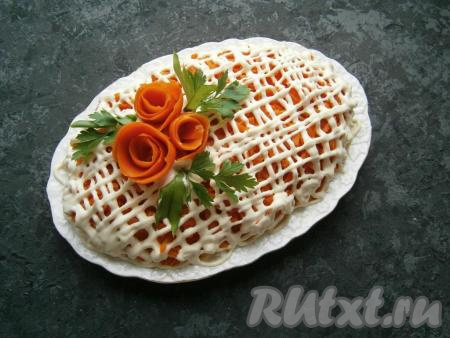 Морковь чуть посолить и нанести сверху густую сетку из майонеза. Слоеный салат украсить розочками из моркови и зеленью.&nbsp;
