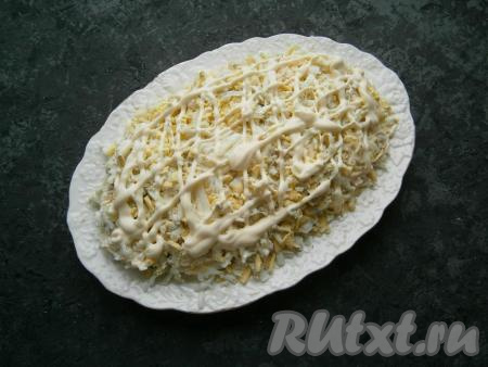 Поверх сыра равномерно распределить натертые на крупной терке вареные яйца, немного посолить, сделать сеточку из майонеза.