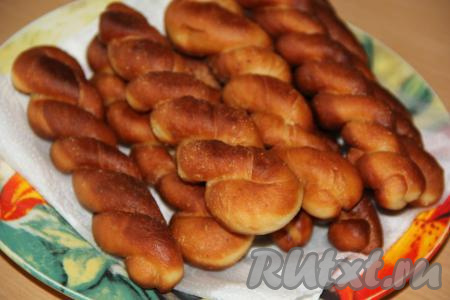 Готовые дрожжевые пончики выкладывать на бумажное полотенце. По форме приготовленные пончики напоминают спирали. Такая необычная форма несомненно понравится многим. Конечно, из теста, замешанного по этому рецепту, можно сделать пончики любой формы. Вне зависимости от формы, пончики получаются нежными, воздушными и необычайно вкусными.