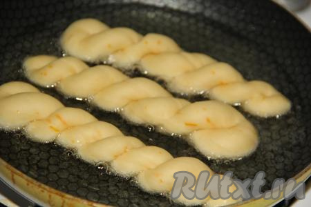 В сковороду влить растительное масло и хорошо его разогреть. Аккуратно выложить пончики в сковороду (масла должно быть достаточно много, оно должно до половины покрывать пончики).