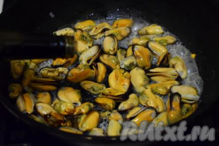 Обжарим мидии на среднем огне до выпаривания половины жидкости, которая выделяется при&nbsp;размораживании морепродуктов на сковороде (в течение 3-4 минут). Затем добавим в сковороду к мидиям соль, чёрный молотый перец, вольем соевый соус и перемешаем.