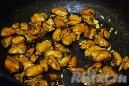 Затем очищенный и мелко нарезанный чеснок добавим в сковороду к мидиям.