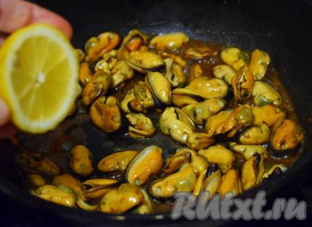 Добавим лимонный сок, потушим мидии на сковороде на небольшом огне, постоянно помешивая, примерно, 2 минуты.