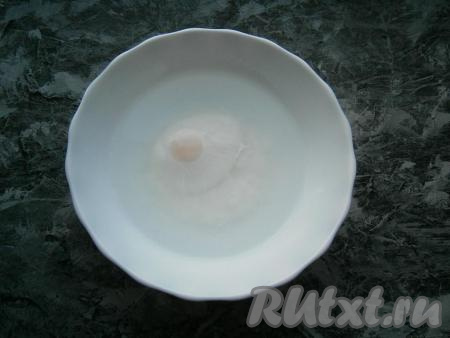 Поместить тарелку с яйцом в микроволновку, выставить время 2 минуты при мощности 700 Ватт. За это время белок свернется и окутает желток. Желток, полностью окутанный белком, останется жидким.