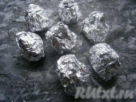 Плотно завернуть каждую картофелину в фольгу.