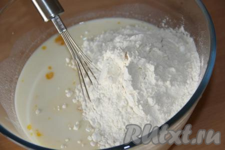 Затем всыпать муку. Венчиком перемешать массу до однородности, а затем влить горячую воду и хорошо перемешать тесто, оно получится не густым. Влить масло и ещё раз перемешать.