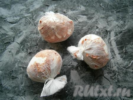 Каждое яйцо завернуть в марлю вместе с луковой шелухой (шелухой должно быть покрыто все яйцо), концы марли завязать нитками или веревочкой (как на фото). Концы марли обрезать.