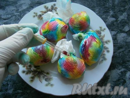 Надев резиновые перчатки, с помощью пипетки&nbsp;капать красители разных цветов на бумагу, в которую завернуты яйца. Бумага должна полностью промокнуть со всех сторон.
