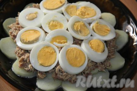 Сварить яйца (в течение минут 10 с момента закипания воды), затем очистить от скорлупы и нарезать кружочками толщиной 1 см. Выложить кружочки яиц поверх рыбы.